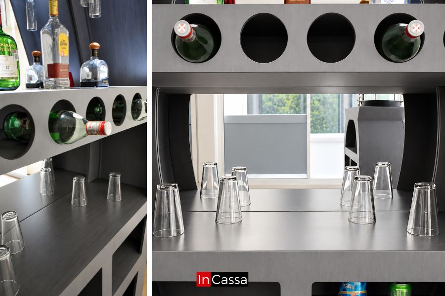 Detalle de la Cantina Redonda con Bancos LUXOR, con botellero horizontal integrado y amplia superficie interior para organizar vasos, copas y accesorios. Incluye espejo posterior que aporta profundidad y facilita la exhibición de bebidas.