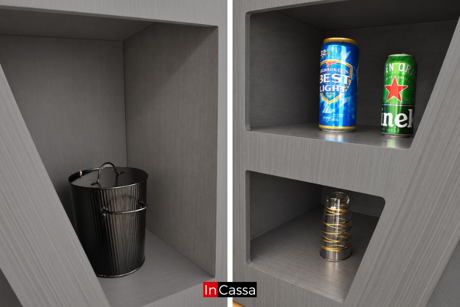 Compartimentos laterales de la Cantina Redonda con Bancos LUXOR en acabado gris cenizo oscuro, diseñados para almacenar y organizar botellas, latas, vasos y accesorios de bar, aprovechando eficientemente el espacio.