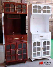 La fotografía muestra el Porta Microondas Modelo ALCALÁ, disponible en dos elegantes versiones: maple oscuro y blanco brillante. Ambos diseños destacan por sus puertas con cristales decorativos, herrajes metálicos dorados y ruedas inferiores para fácil movilidad. Cada modelo cuenta con amplios compartimentos superiores e inferiores, así como un cajón central funcional, ideal para mantener utensilios, vajilla o artículos de cocina siempre organizados.