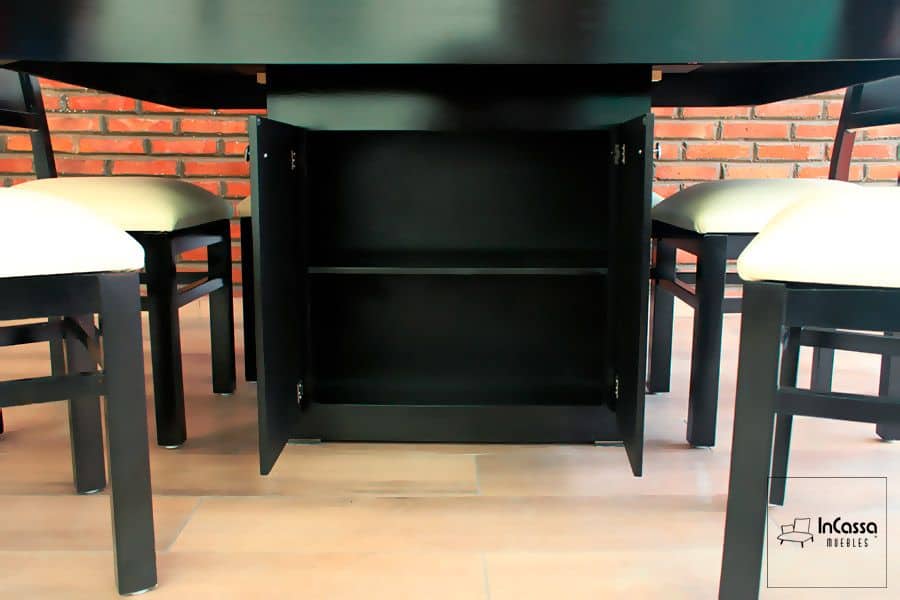 En esta toma se observa el gabinete central del comedor con puertas abiertas y repisa interior, proporcionando un amplio espacio de almacenamiento. El acabado en color chocolate combina con las sillas tapizadas en suede tono hueso, creando un conjunto funcional y elegante.