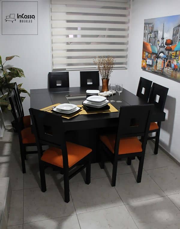 La imagen muestra el Antecomedor Modelo MADRID en su versión para 8 personas, fabricado en elegante color chocolate. Los asientos tapizados en suede naranja aportan un toque vibrante y moderno, mientras el centro de cristal en la mesa complementa su estilo contemporáneo y funcional.