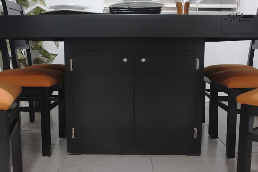 La foto muestra la base central del antecomedor, que integra un gabinete con doble puerta y tiradores metálicos, ideal para guardar vajillas o accesorios. Su acabado en tono chocolate combina perfectamente con las sillas tapizadas en suede color naranja, aportando elegancia y funcionalidad.