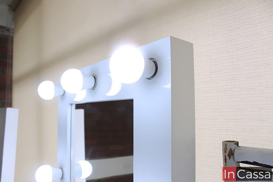 Una toma cercana que resalta el acabado brillante del marco blanco y la potencia de los focos LED instalados. Este tipo de iluminación proporciona una luz clara y uniforme, ideal para maquillaje o cuidado personal, realzando la funcionalidad del tocador Manhattan en cualquier ambiente.