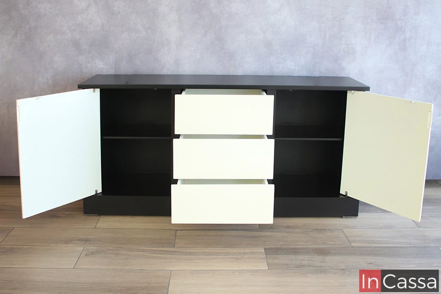 Vemos el bufetero minimalista desde una toma frontal con todas sus puertas y cajones abiertos, mostrando sus interiores los cuales conservan el mismo color negro que la estructura exterior, además las puertas y cajones son de color blanco en su totalidad.