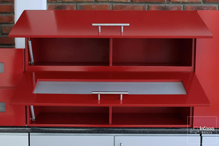 La imagen presenta el módulo superior del modelo MEDELLÍN en color rojo vivo con ambas puertas abiertas, mostrando los espacios interiores divididos y un elegante frente con cristal esmerilado. Los pistones metálicos refuerzan el diseño moderno y funcional del conjunto.
