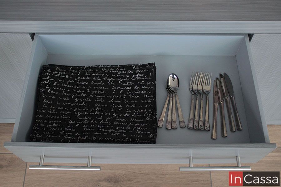 La imagen muestra, desde un ángulo superior, el interior ordenado del cajón del Bufetero MISSISSIPPI en tono gris cenizo claro. Se aprecia perfectamente su amplitud, el fondo uniforme y la solidez del MDF, ideal para utensilios y textiles. Las jaladeras metálicas al frente complementan su estilo moderno y elegante.