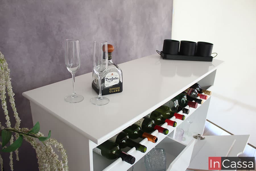 Una toma en la que podemos apreciar mejor la longitud de la cubierta, la cuál es de color blanco con un notable tono brillante al igual que el resto del mueble. También podemos observar el espacio de cava incorporado en la estructura.