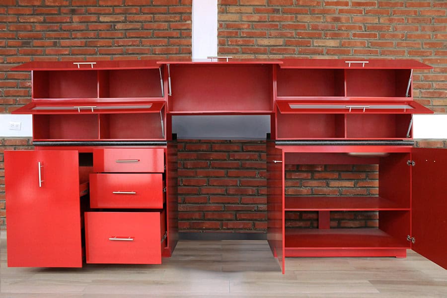 La imagen muestra la Cocina Integral MONTEVIDEO de 2.90m para ESTUFA en color rojo vivo con compartimentos abiertos que permiten apreciar sus cajones funcionales, amplias alacenas abatibles y cubierta de formaica en estilo mármol negro con diseño moderno y vibrante.