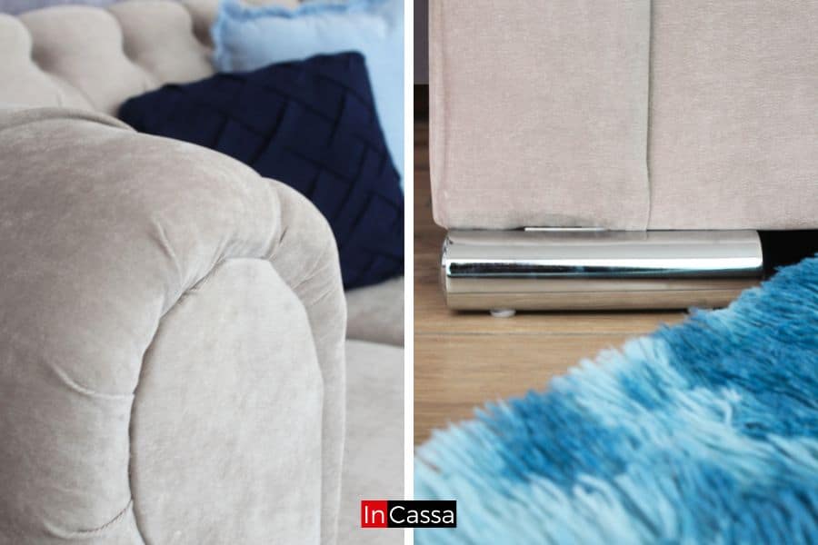 Una toma detallada que destaca los acabados del sofá capitoné tapizado en suede gris perla. A la izquierda, se aprecia el diseño acolchado de los brazos, mientras que a la derecha, se muestra una de las elegantes patas metálicas cromadas, que aportan un toque moderno al conjunto.