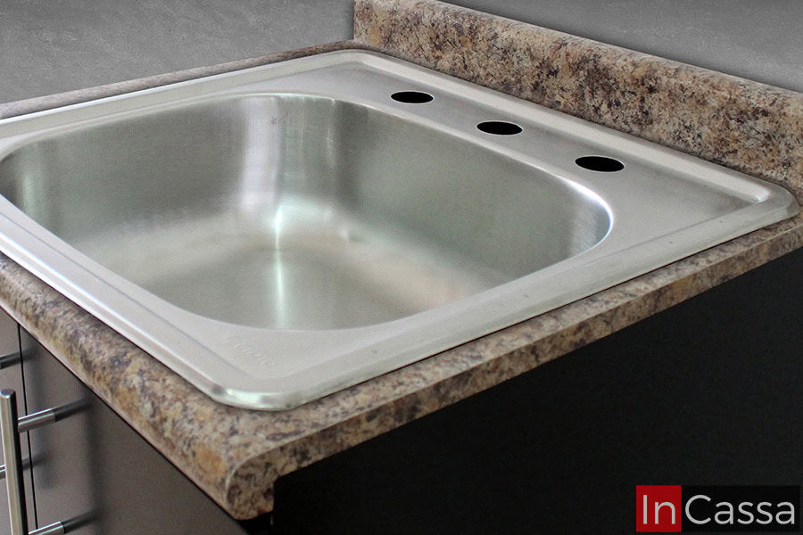 La imagen muestra la tarja de acero inoxidable incluida en la cocina, con tres agujeros para grifos, está montada en una cubierta de formaica en tono piedra salvaje.