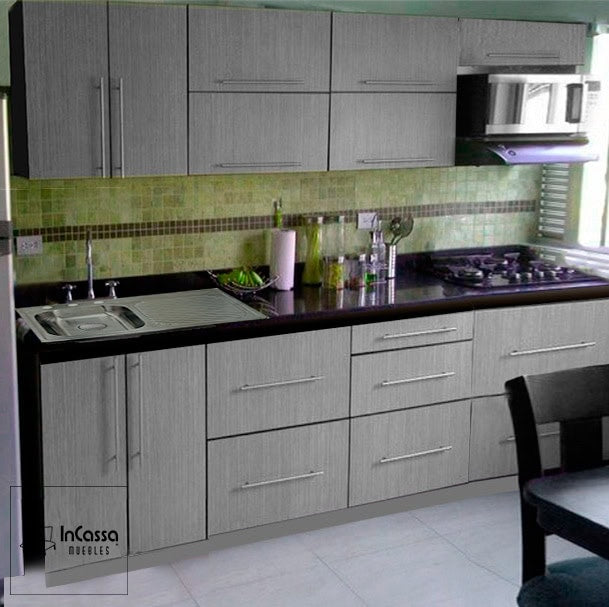 Cocina para parrilla de color gris cenizo oscuro con cubierta de formaica negra, la cocina cuenta con tarja de acera inoxidable y espacio para microondas en el mueble sobre campana.