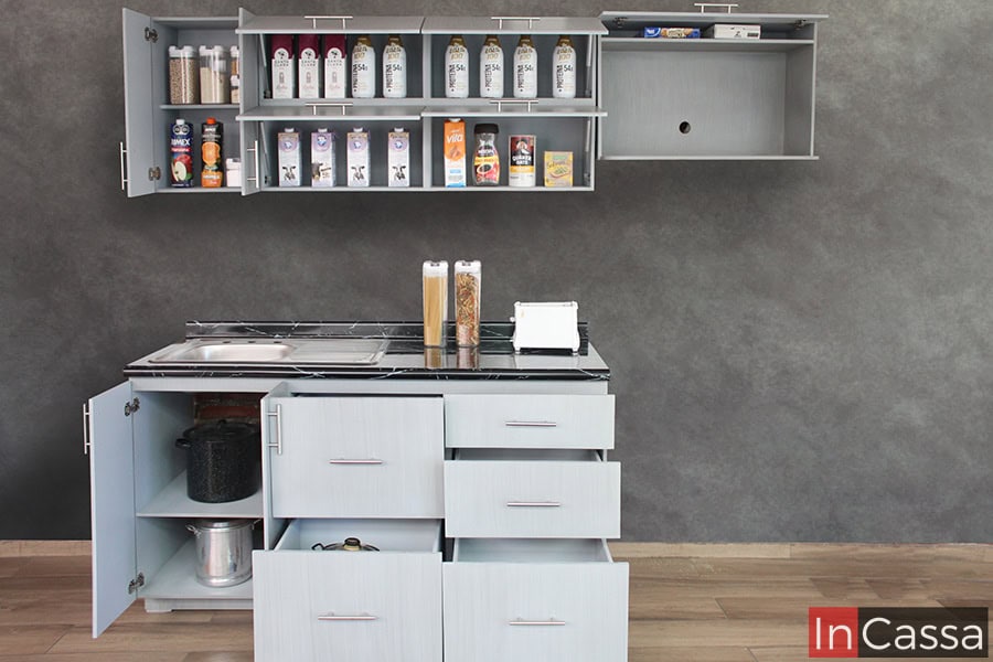 En esta foto se exhiben los módulos de la cocina con todas sus puertas y cajones abiertos, dejando a la vista sus compartimentos interiores, en los cuales se puede notar que conservan el mismo tono gris cenizo claro que las partes exteriores.