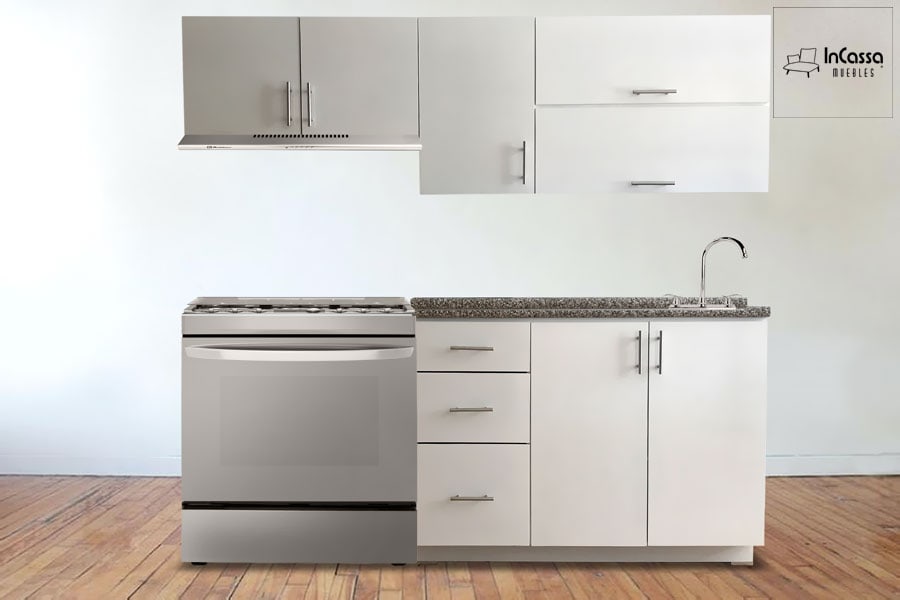 Una fotografía frontal que muestra la Cocina Integral NEVADA para estufa, fabricada en elegante acabado blanco con cubierta de formaica estilo granito purpina. Se aprecian los módulos inferiores con tres cajones funcionales y puertas con jaladeras metálicas, además de los gabinetes superiores en combinación blanco–gris que añaden amplitud y modernidad al espacio.