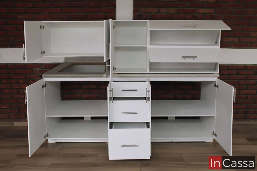 La foto nos presenta la cocina con todos sus módulos abiertos, dejando a la vista todos los espacios con los que cuenta para guardar vajillas y utensilios. Es importante destacar que los interiores mantienen el mismo color blanco que las partes exteriores de la cocina.