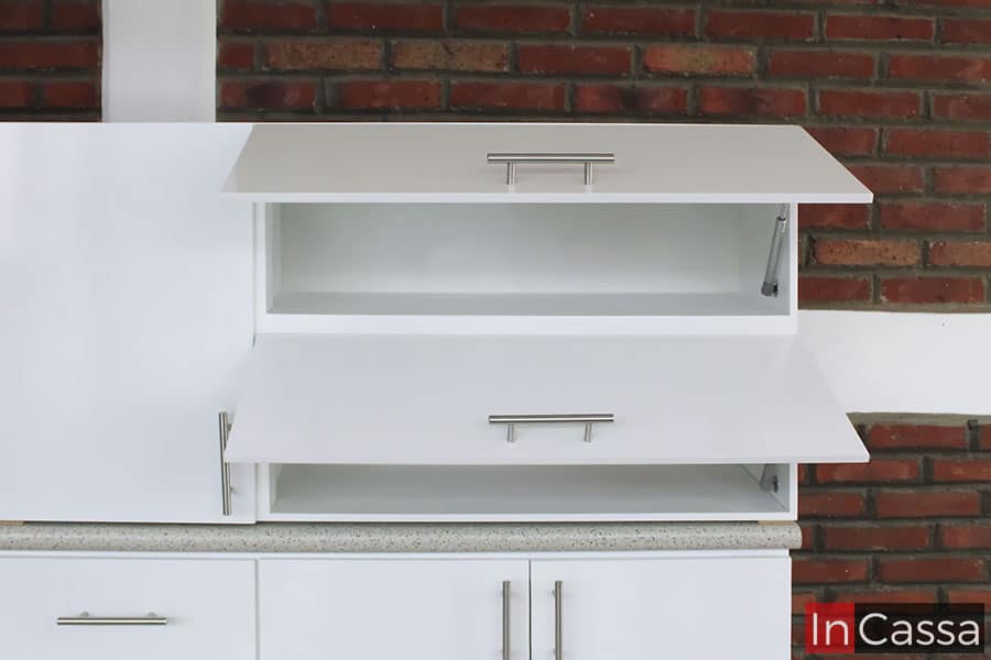 Imagen del módulo sobre tarja de color blanco completo, resaltando dos de los espacios con los que cuenta, los cuales poseen un sistema de apertura y cierre vertical guiado por pistones neumáticos además de jaladeras metálicas estilo T.