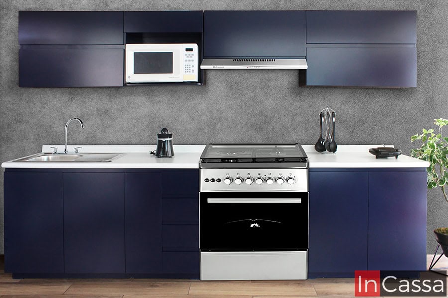 En esta fotografía se aprecia la Cocina Integral NICARAGUA completamente montada con una estufa de 30″, que se integra armoniosamente entre los módulos inferiores. El diseño lineal en tono azul rey mate destaca sobre el fondo gris texturizado, mientras la cubierta de formaica blanco fresh y los electrodomésticos en acero inoxidable complementan el estilo moderno y funcional del conjunto.