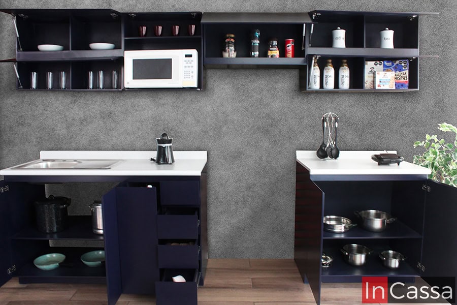 La imagen muestra una toma frontal con todos los módulos abiertos de la Cocina Integral NICARAGUA para estufa, revelando su increíble capacidad de almacenamiento. Se aprecian alacenas superiores con puertas elevables tipo pistón, espacios para microondas, vasos, cereales y botellas; además de módulos inferiores con cajones, tarja, puertas abatibles y repisas para ollas y sartenes. Todo en un elegante acabado azul rey con cubierta blanco fresh.