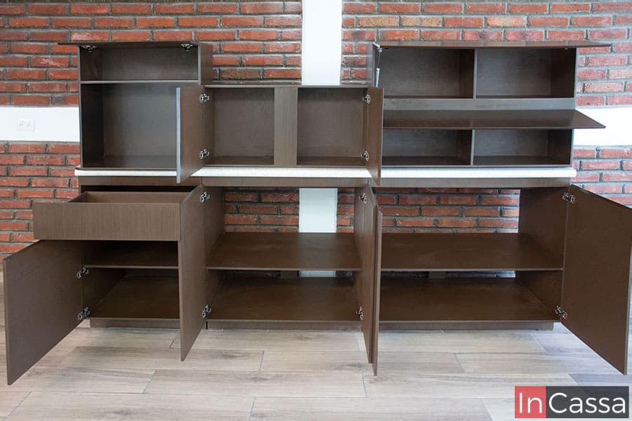 La cocina se presenta con todas sus puertas abiertas dejando a la vista los interiores de cada módulo, estos cuentan con una amplia variedad de compartimentos pintados en color café.