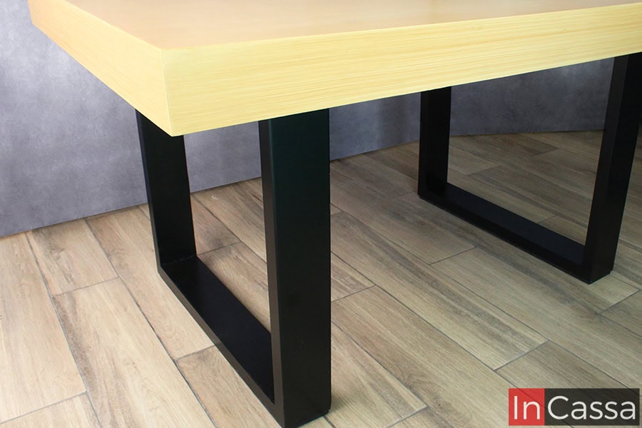 La imagen destaca el diseño robusto y moderno del pedestal de la mesa del Comedor NORMANDÍA, elaborado en estructura de MDF color negro con forma rectangular, brindando firmeza y un look industrial. La cubierta en tono madera natural con vetas horizontales aporta calidez al contraste, logrando una combinación estética ideal para espacios contemporáneos y nórdicos.
