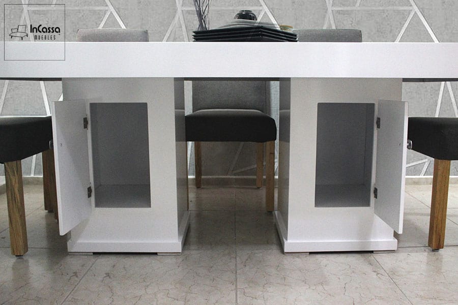 En esta foto, la mesa del comedor revela un diseño funcional, con pedestales blancos que, además de sostener la estructura, esconden compartimentos con puertas, ideales para almacenamiento discreto.