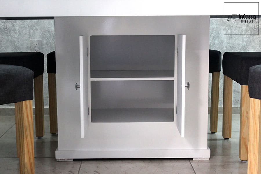 La imagen muestra en detalle el compartimento interno de la base de la mesa del comedor, el cual está dividido en dos secciones mediante una repisa central. Este espacio es ideal para organizar y almacenar diversos objetos, aprovechando al máximo el diseño funcional de la mesa sin sacrificar su estética moderna y elegante.