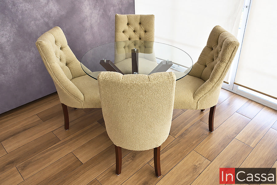 Vista completa del Comedor Redondo OVIEDO en color tabaco, con cubierta circular de vidrio que permite apreciar su original base geométrica. Sus cuatro sillas capitoneadas en sherpa buclé borrego beige rodean la mesa con una distribución acogedora, elegante y visualmente equilibrada.