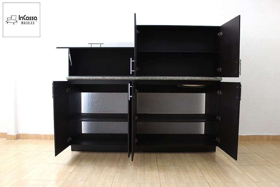 La foto muestra la cocina Palmeira con todas sus puertas abiertas, revelando interiores espaciosos, en acabado chocolate completo, con repisas funcionales para almacenar desde despensa hasta utensilios. Práctica, moderna y pensada para el día a día.