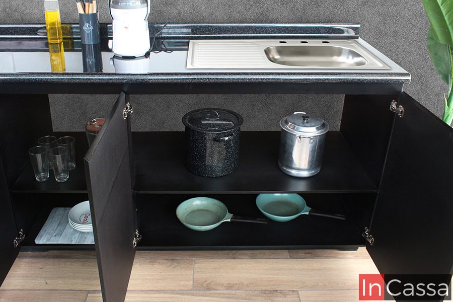 Debajo de la tarja de acero inoxidable, la cocina de color chocolate ofrece un espacio de almacenamiento adicional, ideal para organizar ollas, sartenes y utensilios grandes, optimizando cada rincón.