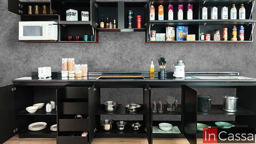 Con todos los módulos abiertos, la cocina, en acabado chocolate completo, exhibe su capacidad de almacenamiento, ideal para organizar desde alimentos enlatados hasta ollas y sartenes. Cada espacio está diseñado para aprovechar al máximo la funcionalidad.
