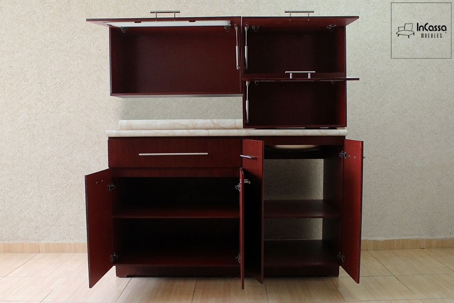 La foto muestra la cocina abierta, exhibiendo su acabado maple completo, revelando amplios compartimentos superiores e inferiores, ideales para almacenar utensilios y alimentos con total comodidad y orden.