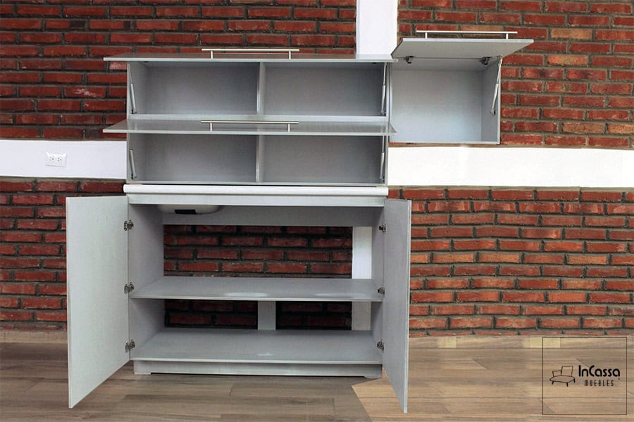 Una toma general que revela el amplio interior del modelo PISA para Estufa, mostrando tanto alacenas superiores como módulo inferior con todas sus puertas abiertas. Se destacan los compartimentos organizados, repisas internas y pistones neumáticos en puertas elevables. El acabado en gris cenizo claro brinda un estilo contemporáneo y funcional.