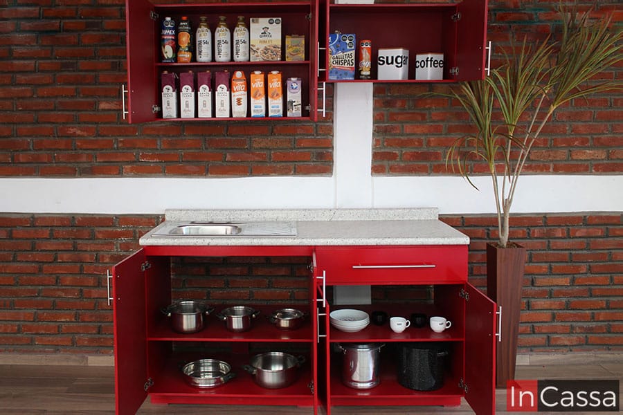 Una presentación de la cocina con todos sus compartimentos abiertos, sumando un total de siete amplios espacios entre todos los módulos. La cocina mantiene el color negro tanto en las partes interiores como en las exteriores. La imagen también son enseña una cubierta completa en estilo sal y pimienta con una tarja de acero inoxidable incorporada.