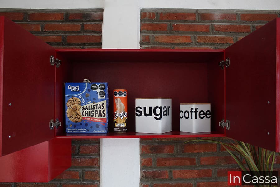 Foto que nos muestra el interior del módulo sobre campana, en el que a primera vista podemos ver que conserva un acabado rojo en toda su estructura. También podemos ver que el compartimento presenta algunas cajas de alimentos para poder hacerse una idea de su capacidad de almacenamiento.