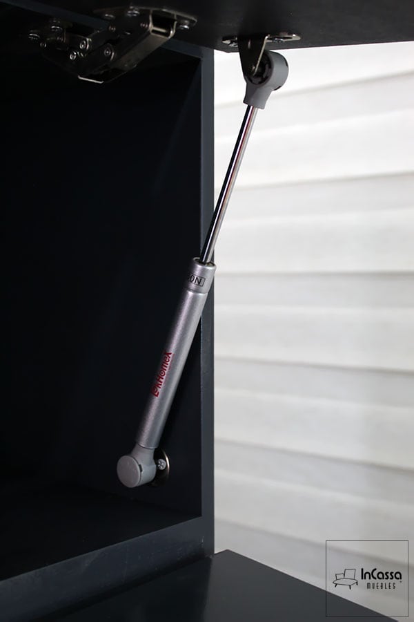 La imagen resalta el pistón neumático metálico instalado en la alacena superior de la Cocina Integral QUEBEC para Estufa, diseñado para ofrecer apertura y cierre suaves y controlados. Su mecanismo garantiza mayor seguridad y comodidad durante el uso diario, evitando golpes o caídas bruscas. Fabricado con materiales de alta resistencia y herrajes de precisión, este sistema refuerza la calidad del mueble y refleja la atención al detalle característica de InCassa Muebles.