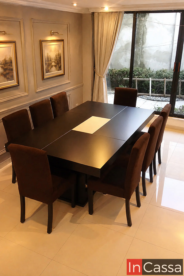 Se aprecia el Comedor Modelo RABAT para 8 personas en color chocolate con asientos tapizados en suede chocolate, un diseño de gran presencia que combina líneas contemporáneas con acabados cálidos y elegantes. Su amplia cubierta brinda espacio para compartir cómodamente con familiares o invitados, mientras que las sillas tapizadas ofrecen excelente confort, convirtiéndolo en la opción ideal para comedores modernos y reuniones especiales.