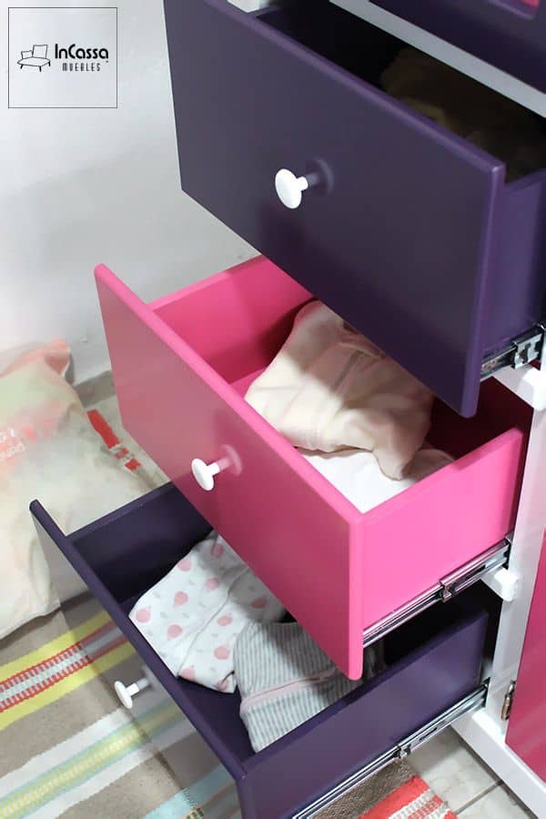 En esta toma se observan los cajones del Roperito Infantil Modelo ROMINA en funcionamiento, mostrando su amplitud y practicidad para organizar la ropa infantil. Los tonos uva y rosa pastel añaden un toque divertido al diseño, mientras que las correderas metálicas garantizan un deslizamiento suave y duradero.