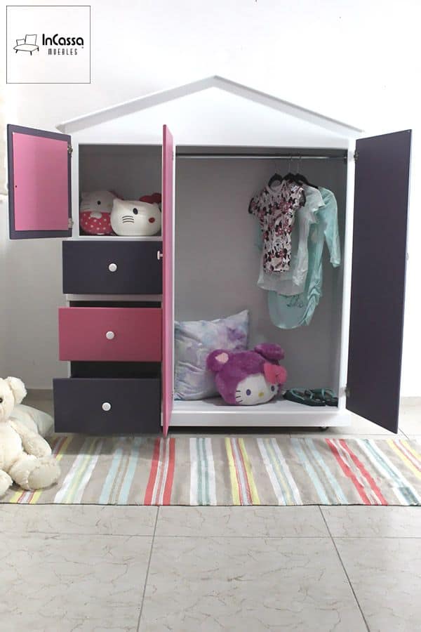 La fotografía muestra el interior del Roperito Infantil Modelo ROMINA, destacando su amplio espacio con barra para colgar ropa, tres cajones inferiores y un compartimento superior ideal para juguetes o accesorios. Su estructura blanca con detalles en rosa pastel y uva crea un ambiente alegre y organizado para el dormitorio infantil.