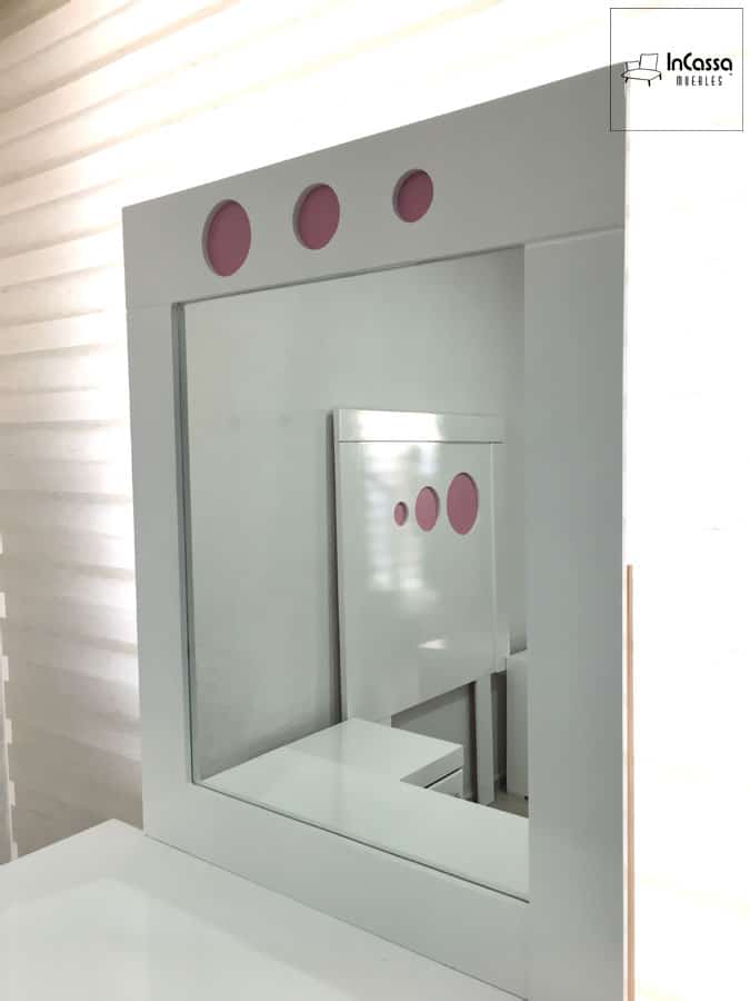 Una toma del espejo del tocador blanco que resalta los detalles decorativos en color rosa. Ideal para complementar el diseño moderno y funcional del mueble, agregando estilo a cualquier habitación.
