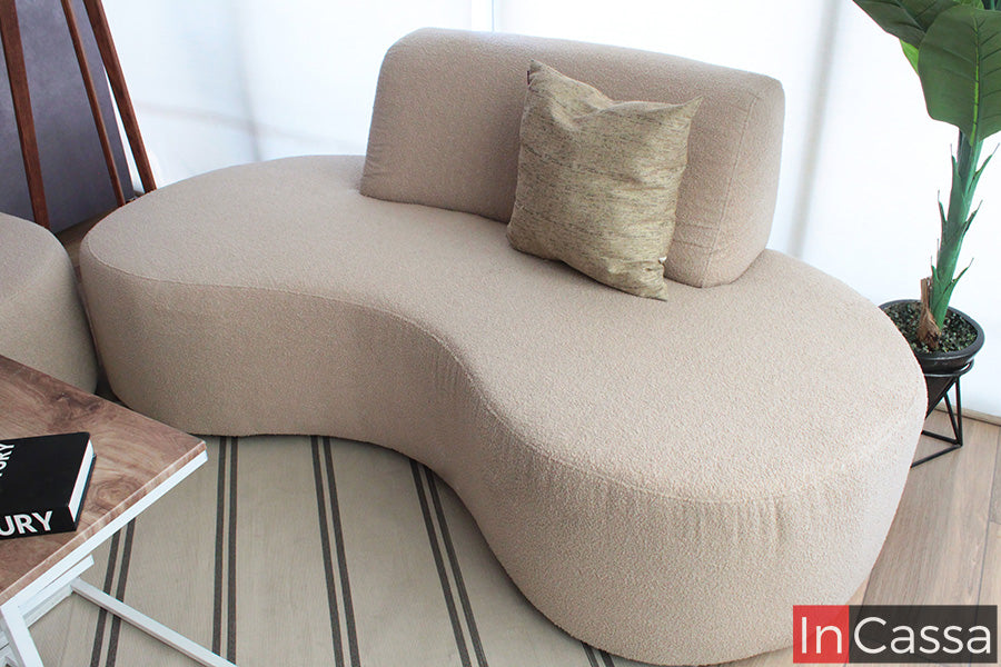 La toma en ángulo resalta el diseño orgánico de la Sala Redonda Modelo SALÓNICA, tapizada en suede gris perla. Sus curvas fluidas y acabado texturizado aportan calidez y un estilo moderno, ideal para crear espacios elegantes y acogedores.