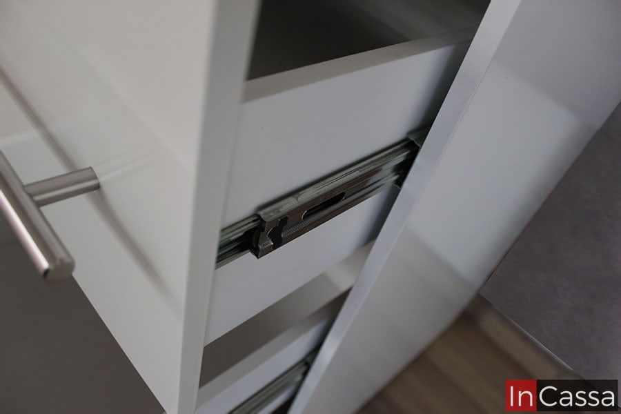 Observamos el mecanismo interno de apertura de los cajones, el cuál consta de un sistema de rieles. Es posible observar que los cajones tienen un acabado blanco tanto interna como externamente.