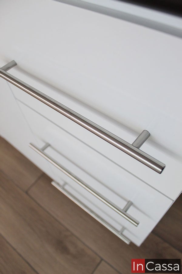 La imagen muestra las jaladeras plateadas incorporadas en cada uno de los cajones, los cuales se muestran en color blanco.