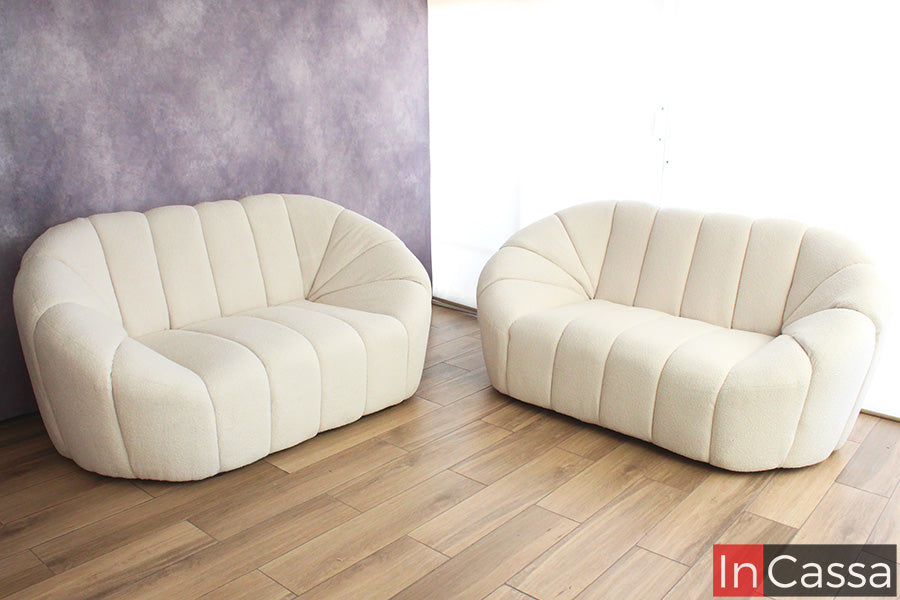 Se presenta una toma frontal que resalta la silueta envolvente de la sala SAMARA en suede color hueso; sus líneas curvas y capitoné vertical crean una estética moderna y suave, ideal para espacios luminosos donde se busca elegancia, amplitud y confort visual.