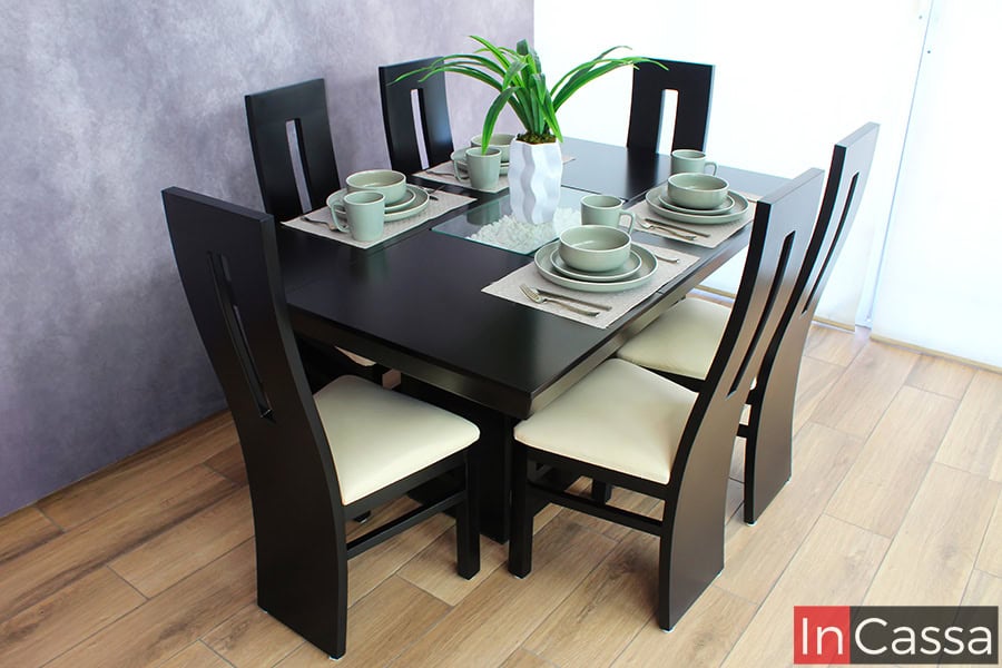 La imagen presenta un comedor contemporáneo de seis sillas con acabado en color chocolate y elegante arenero central. Las sillas de color chocolate cuentan con respaldo curvo calado y asientos tapizados en suede hueso.