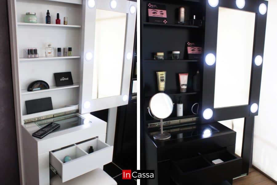 Una toma cercana revela los cajones abiertos en ambos tocadores, blanco y negro, con divisiones internas para organizar maquillaje y accesorios. Los estantes y espejos iluminados completan su diseño funcional y elegante.