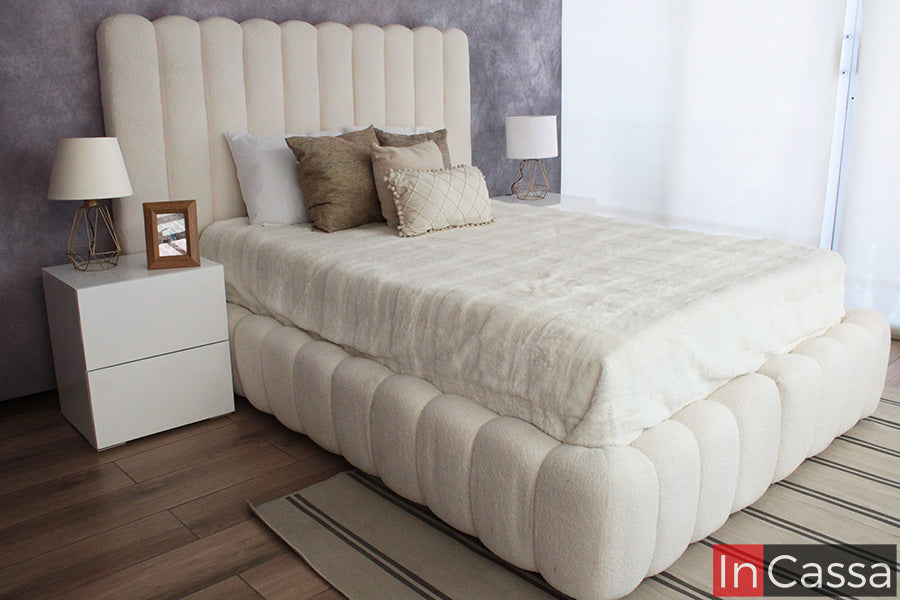La imagen presenta la Recámara Viral Estilo Pinterest modelo SEDONA tapizada en suede hueso, acompañada de burós en color blanco. Su diseño envolvente, cabecera alta acolchada y acabado suave crean un ambiente elegante, cálido y totalmente en tendencia.