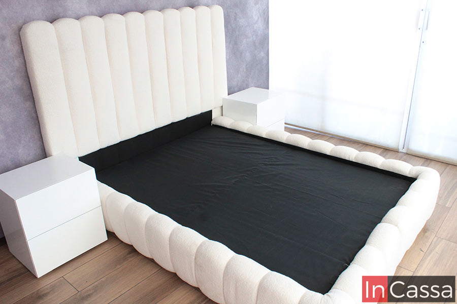 La fotografía muestra la Base de Cama Viral Estilo Pinterest modelo SEDONA tapizada en suede hueso, con diseño envolvente y cabecera alta acolchada. Sus formas curvas y acabado suave crean una recámara moderna, acogedora y totalmente elegante.