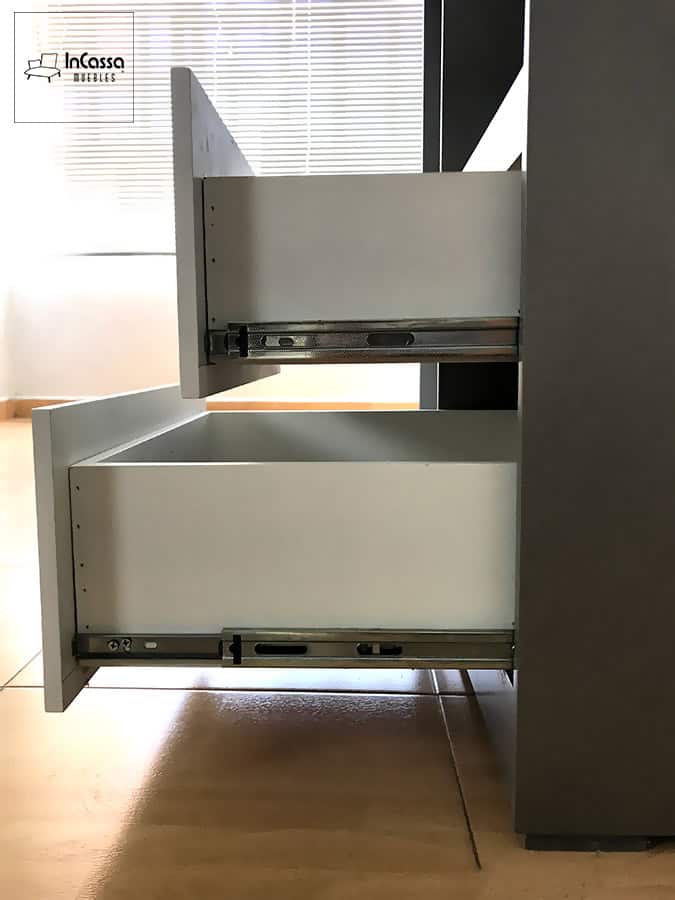 La fotografía muestra una vista lateral del guardarropa SHANGHAI con cajones blancos completamente extendidos, destacando las correderas metálicas de extensión total que brindan apertura amplia y acceso cómodo. El acabado plata del mueble y el frente blanco de los cajones mantienen el estilo moderno y elegante del diseño.