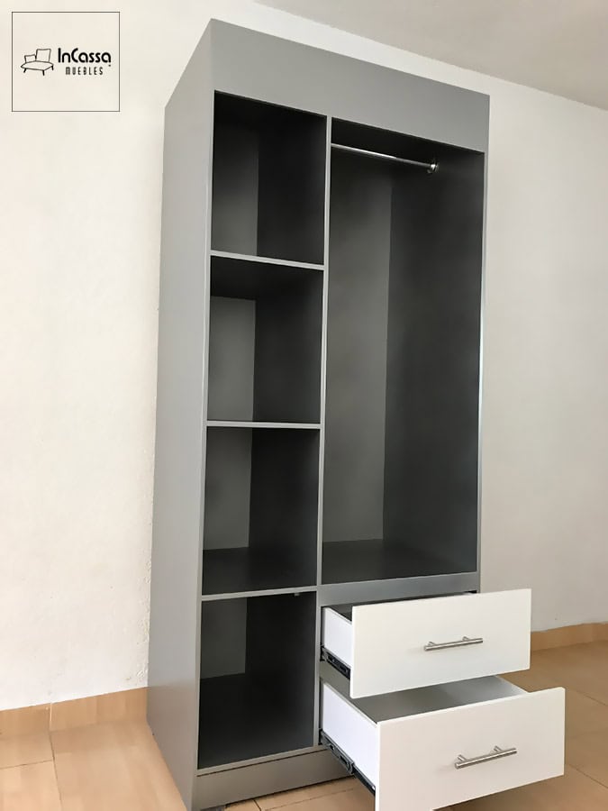 La imagen muestra el guardarropa SHANGHAI en color plata, con repisas abiertas, espacio para colgar prendas y cajones blancos extendidos con correderas metálicas. El diseño luce moderno y listo para organizar ropa y accesorios.