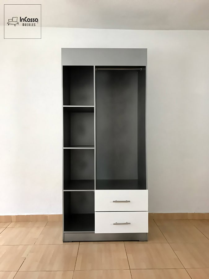 La fotografía muestra el guardarropa SHANGHAI en color plata con una vista totalmente frontal. A la izquierda aparecen sus cuatro compartimentos verticales, ideales para ropa doblada o accesorios; mientras que a la derecha se aprecia el espacio largo con tubo metálico para colgar prendas. En la parte inferior destacan dos cajones blancos con jaladeras de acero, perfectos para organizar ropa interior o artículos personales.