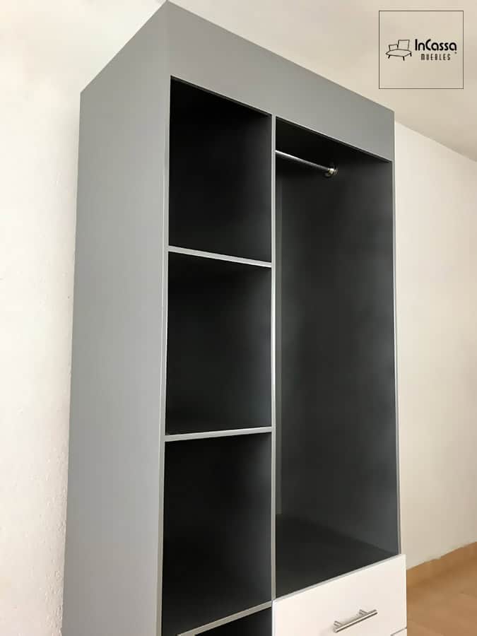 La foto muestra el guardarropa SHANGHAI en color plata, destacando sus amplias repisas abiertas y el tubo metálico para colgar ropa. El diseño luce moderno, práctico y combina perfectamente con los cajones blancos del módulo inferior.